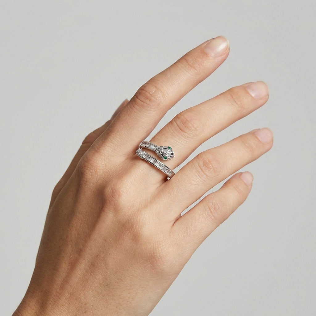 Snake ring with green eyes on a woman's finger, baguette stones sparkling