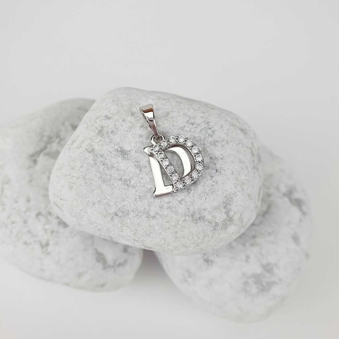 Initial D pendant with cubic zirconia on light stones, side close-up