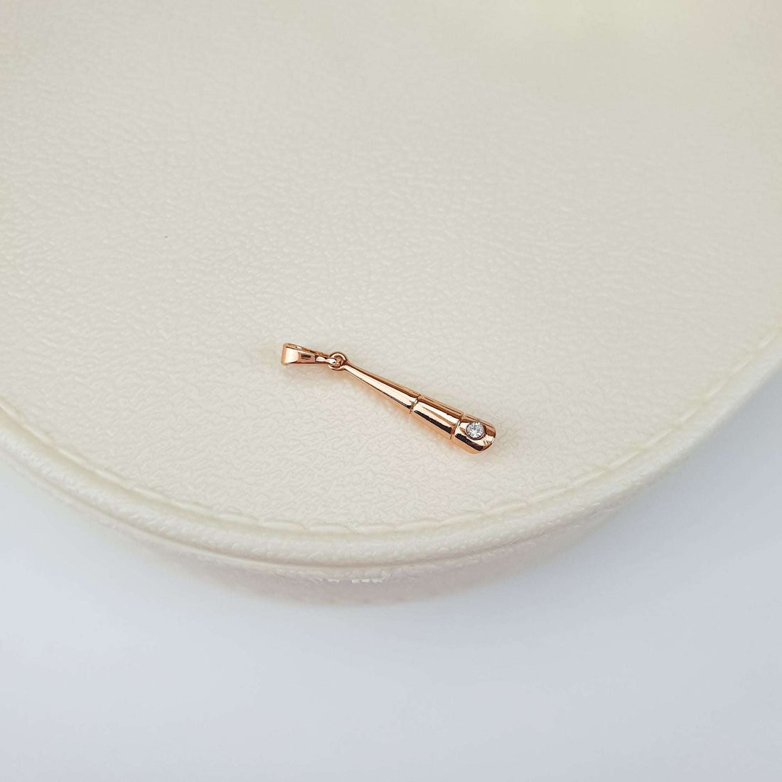 Minimalist cone pendant with a cubic zirconia on a light leather box