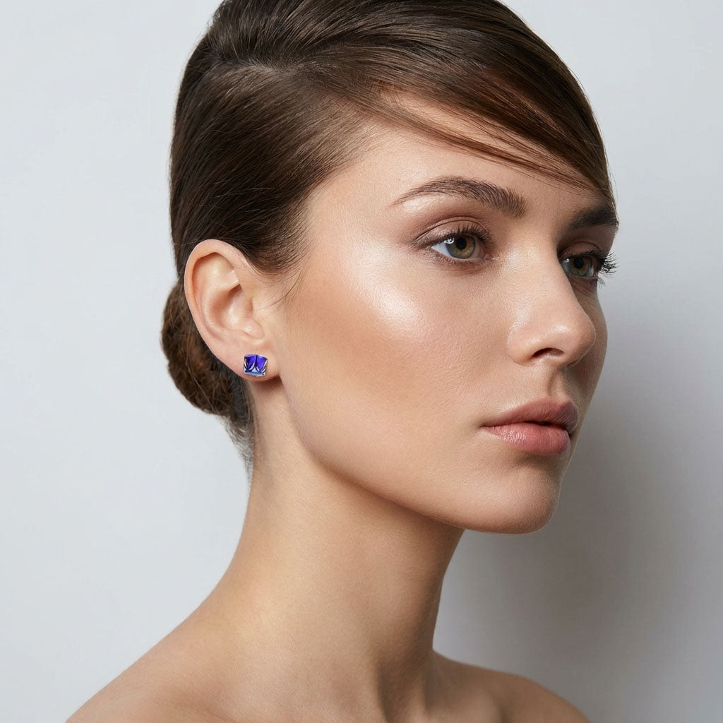 Model wearing a violet-blue cube crystal stud, side view on a light background