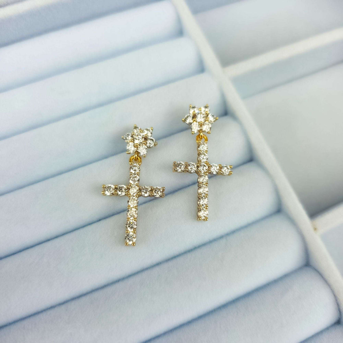 Cross earrings with a cubic zirconia flower in a light blue jewellery box