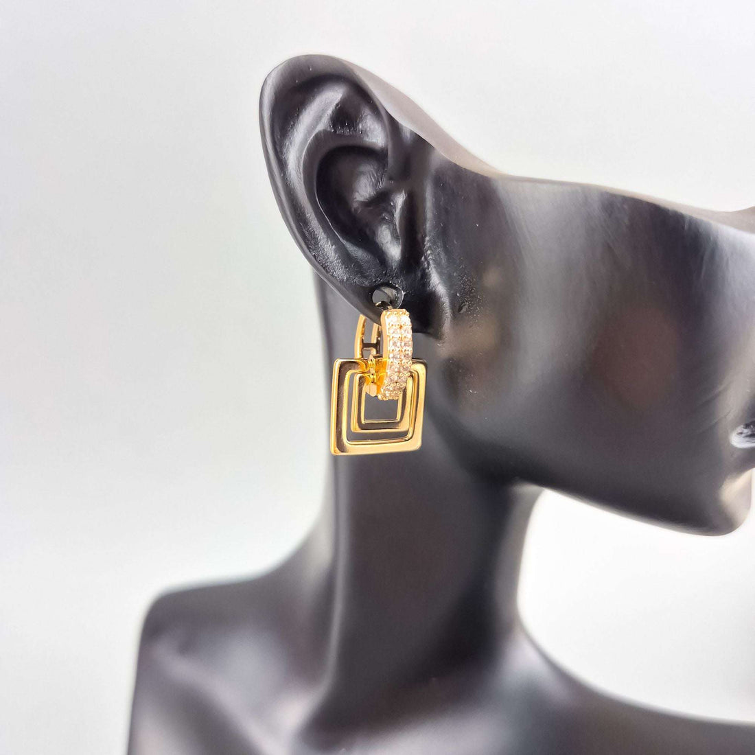Square earring with a double frame and cubic zirconia on a mannequin ear