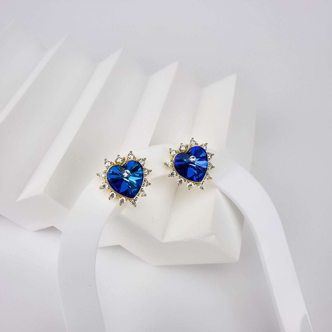 Pair of blue heart crystal studs framed by clear cubic zirconia