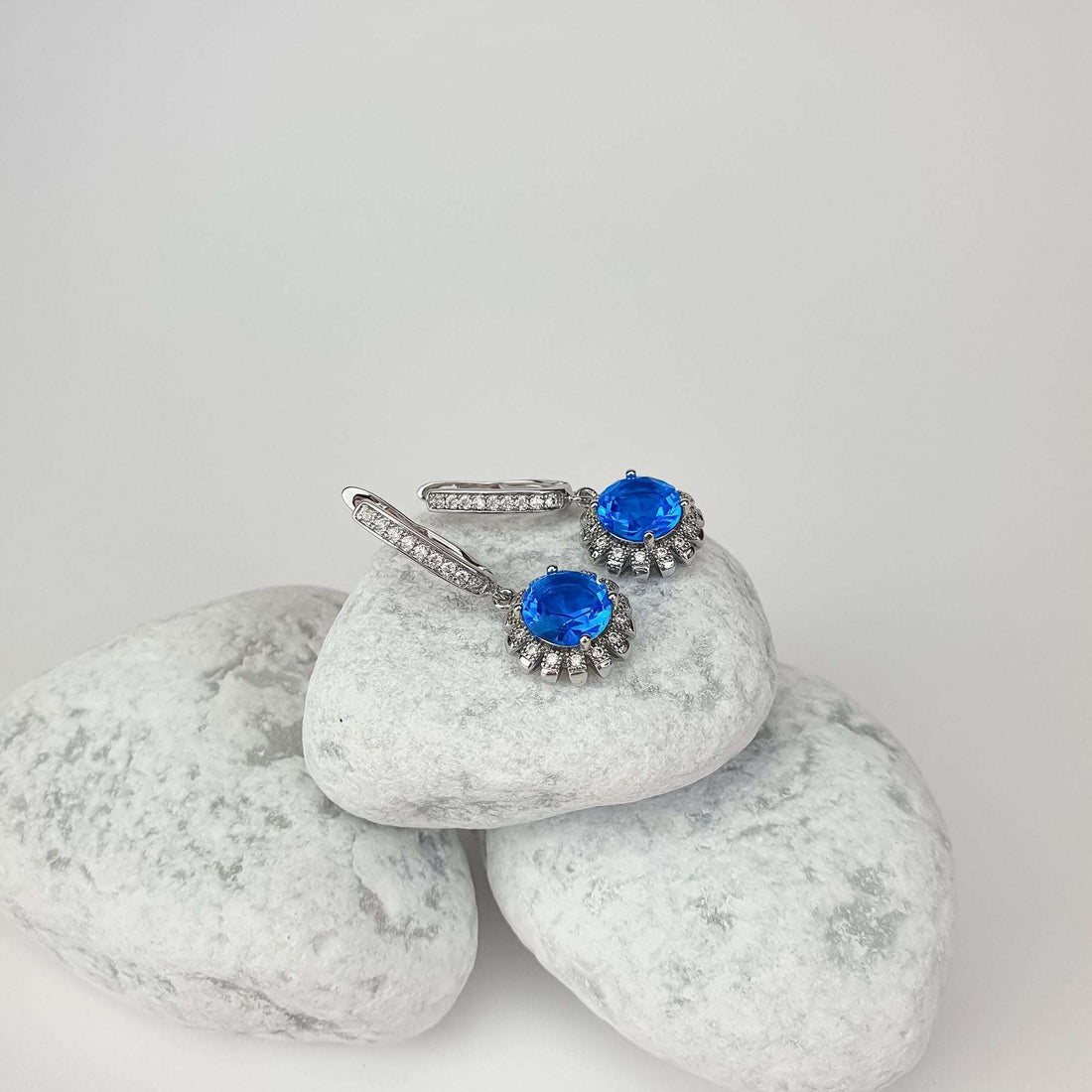 Blue crystal earrings on white stones, side view of leverback clasp with cubic zirconia