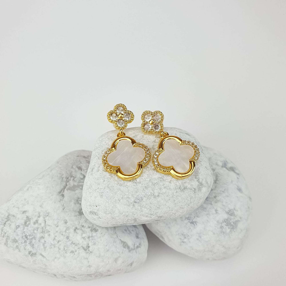 Mother-of-pearl clover drop earrings with cubic zirconia, gold-plated frames, on light stones