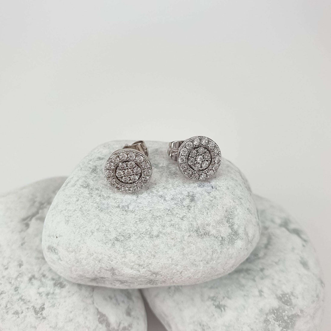 Cubic zirconia rosette studs on white pebbles with the push-back fastening clearly visible