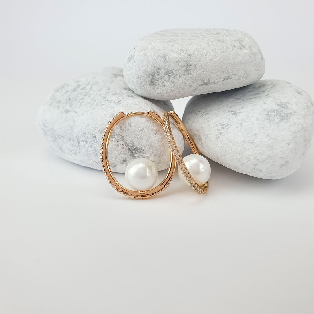 Oval earrings with faux pearls inside the hoops and leverback clasps on light stones