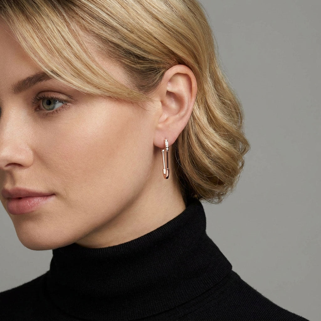 Woman in a black polo neck wearing a gold-plated safety pin earring
