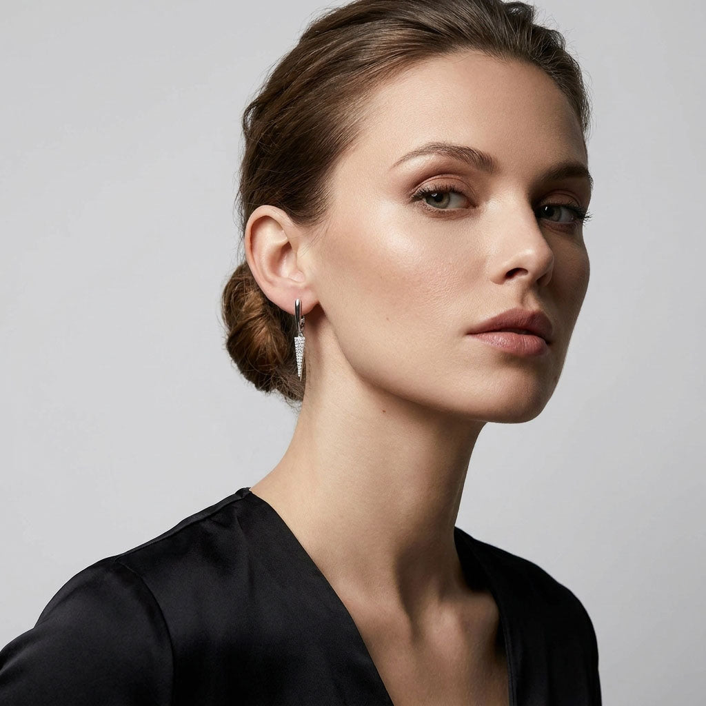 Woman in a black blouse wearing a slim, sparkling silver-tone earring