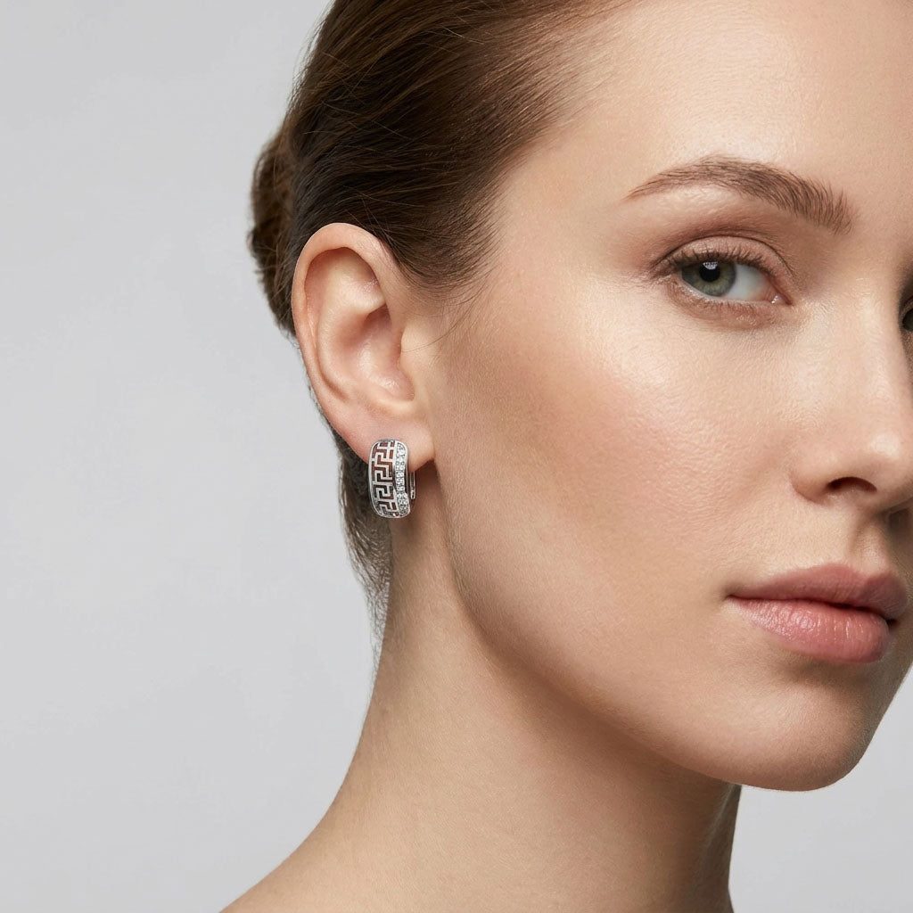 Compact silver-tone Greek pattern earring on a model's ear