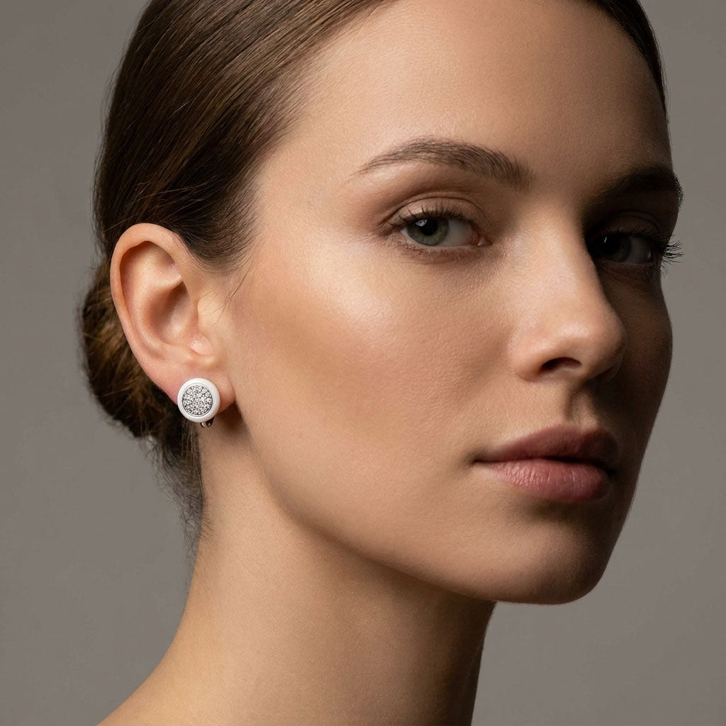 Round white ceramic earring with a sparkling zirconia circle in a woman's ear
