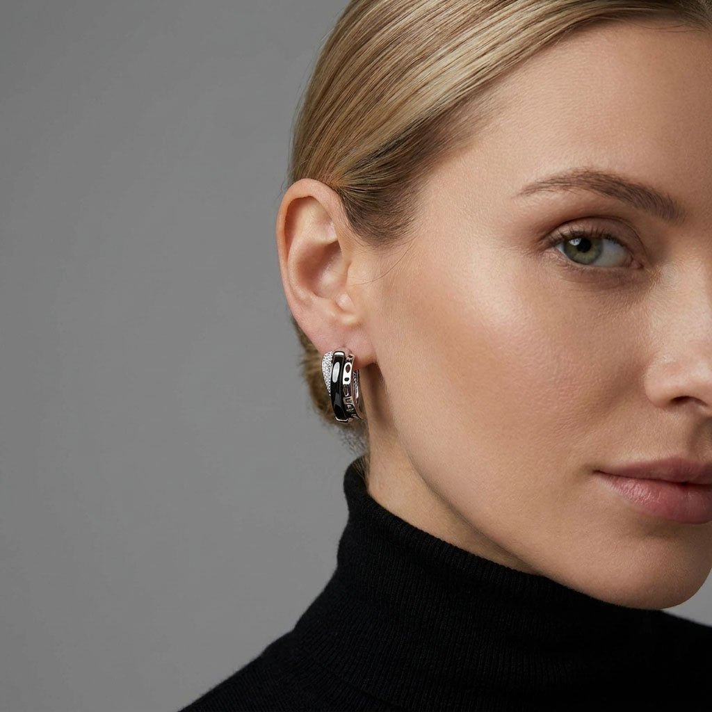 Model wearing black ceramic earrings, rhodium shine against a black polo neck