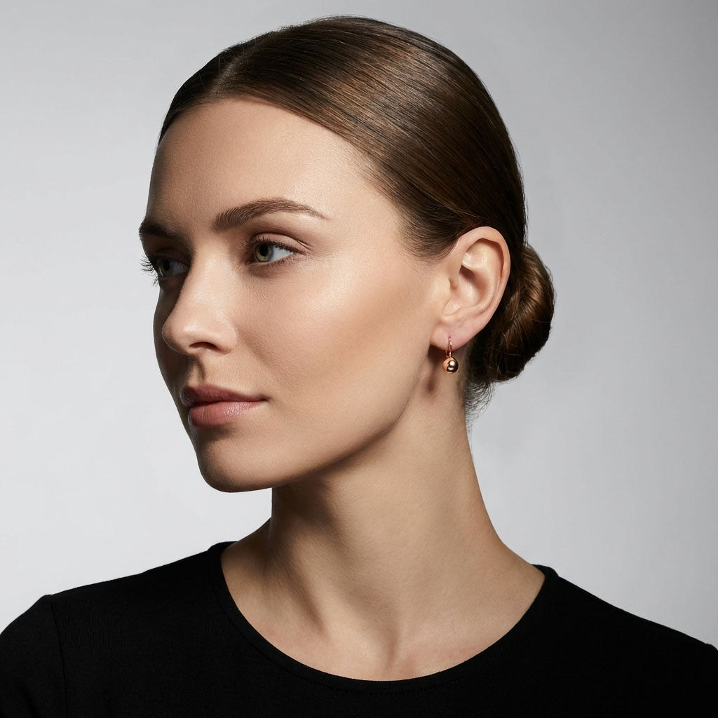 Model wearing a gold-plated ball earring, a classic accent to a black outfit