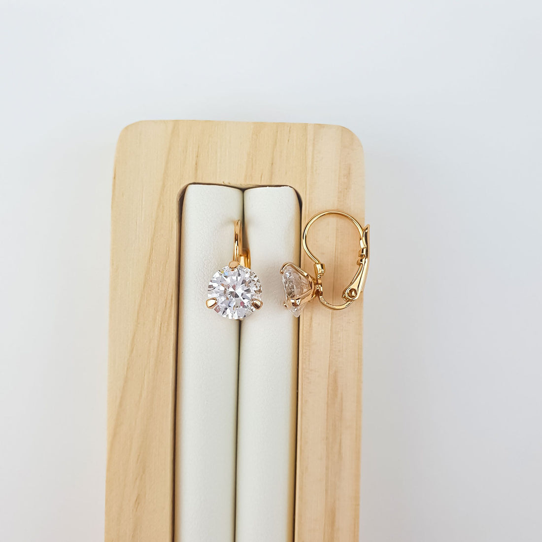 Clear cubic zirconia earrings on a wooden stand, showing the hook in profile