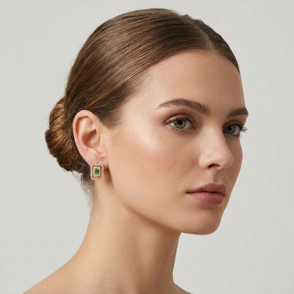 Model with her hair up wearing a gold-plated earring with a green rectangular stone