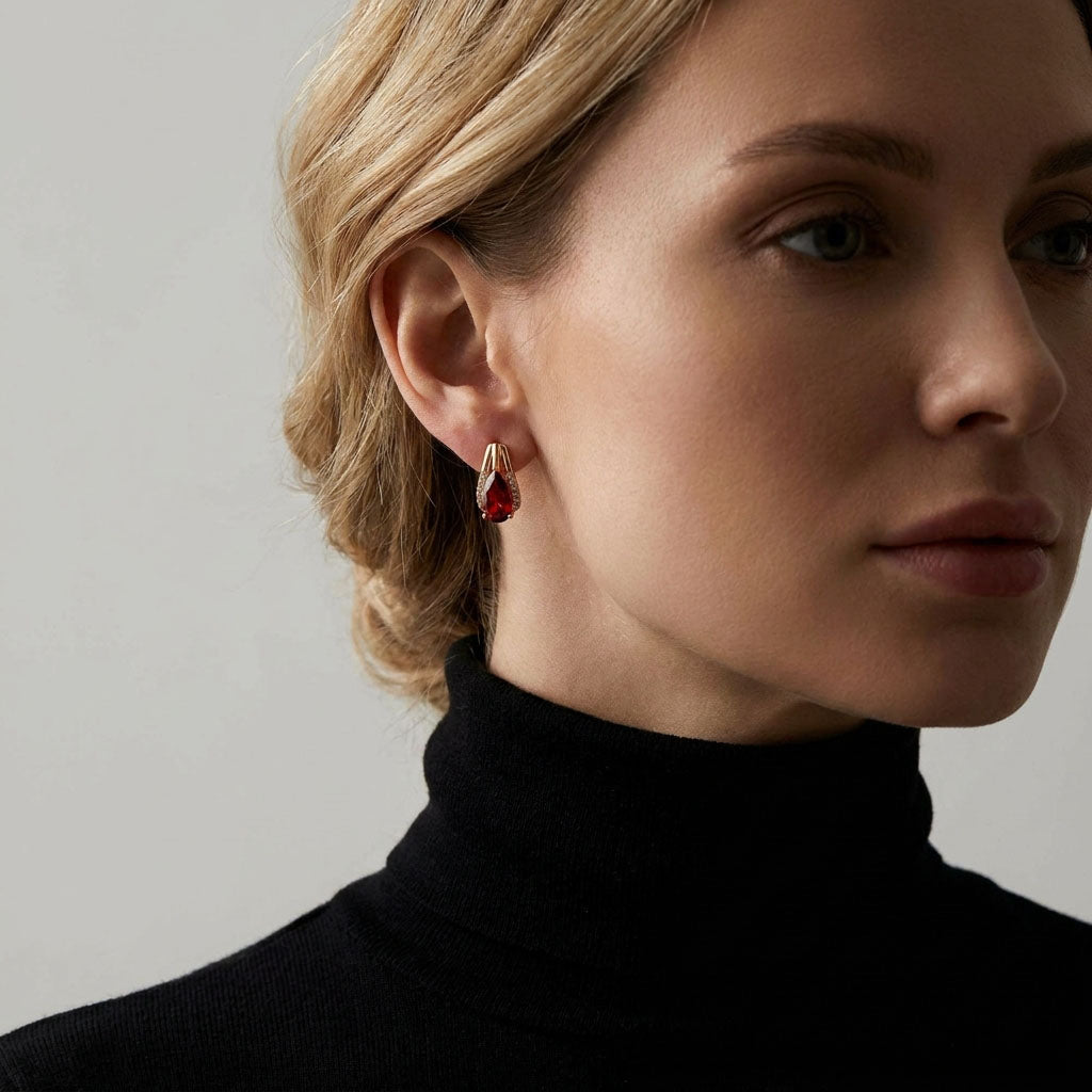 Model in a black polo neck wearing a gold-tone red teardrop earring