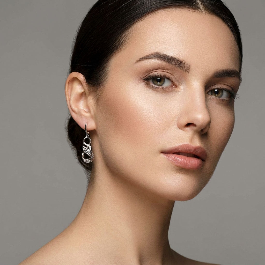 Model wearing silver-tone Greek pattern drop earrings against a grey background