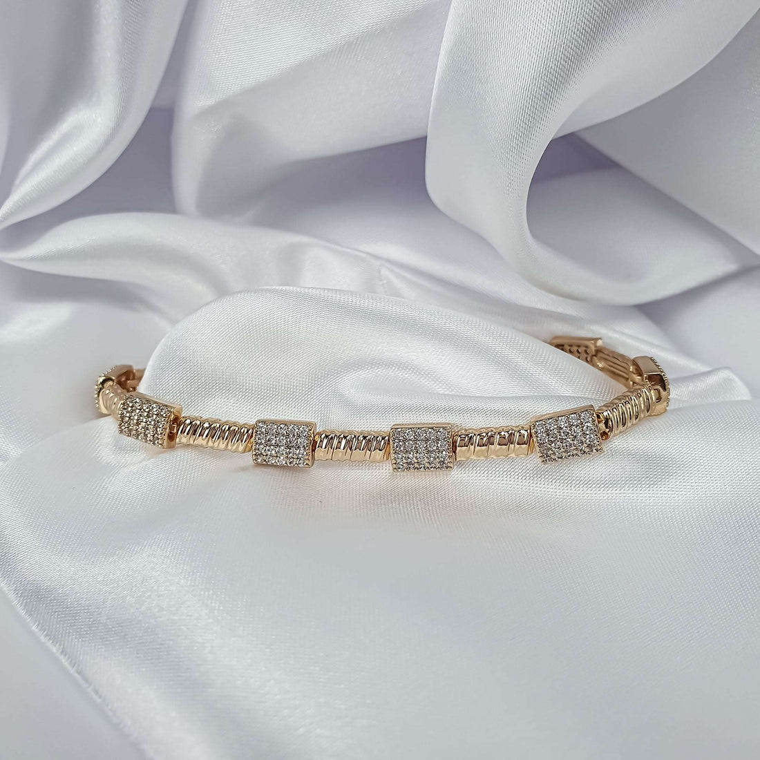 Gold-plated ribbed bracelet with four square cubic zirconia plates on satin