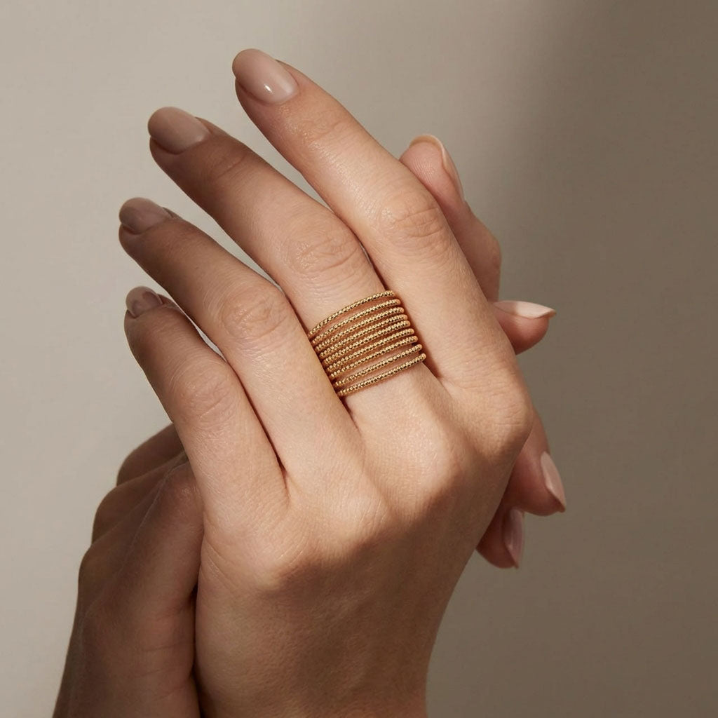 Multi-row gold-tone ring on a model's finger, showing its width