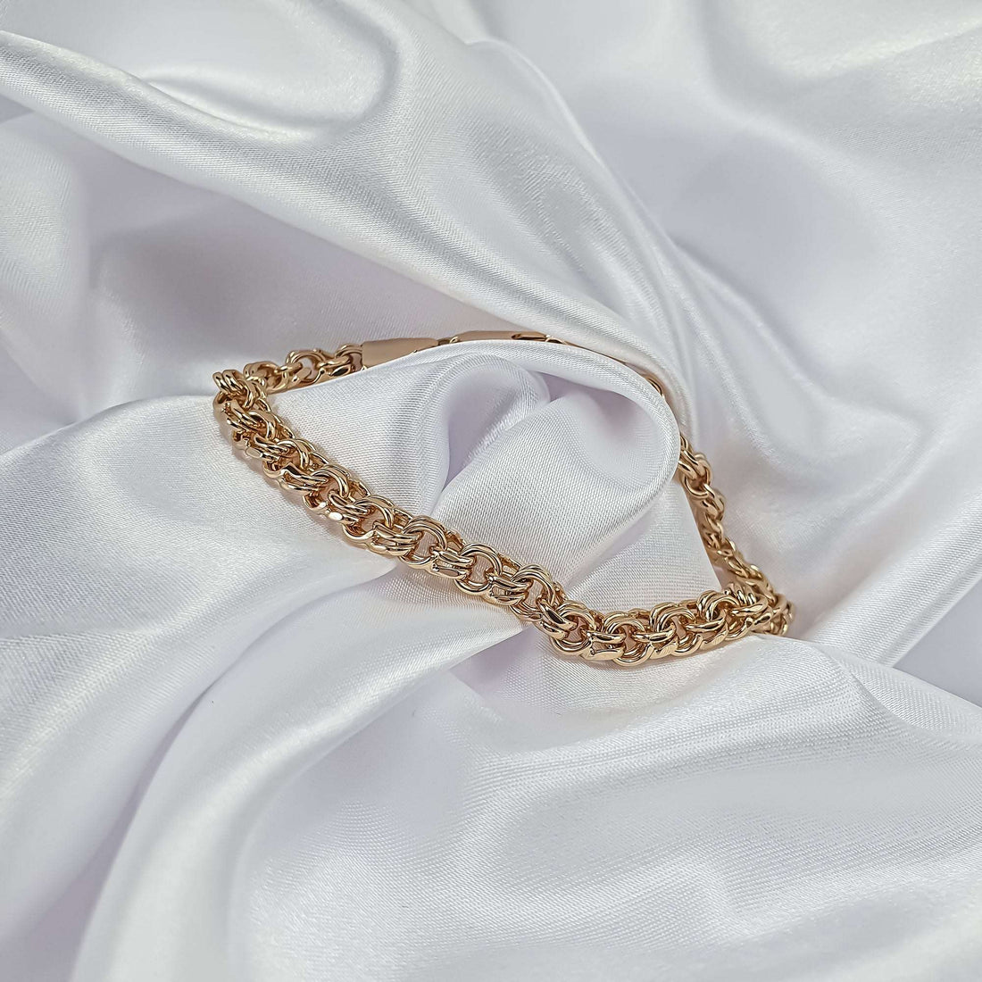 Gold-plated men's bracelet with a thick weave on white satin folds