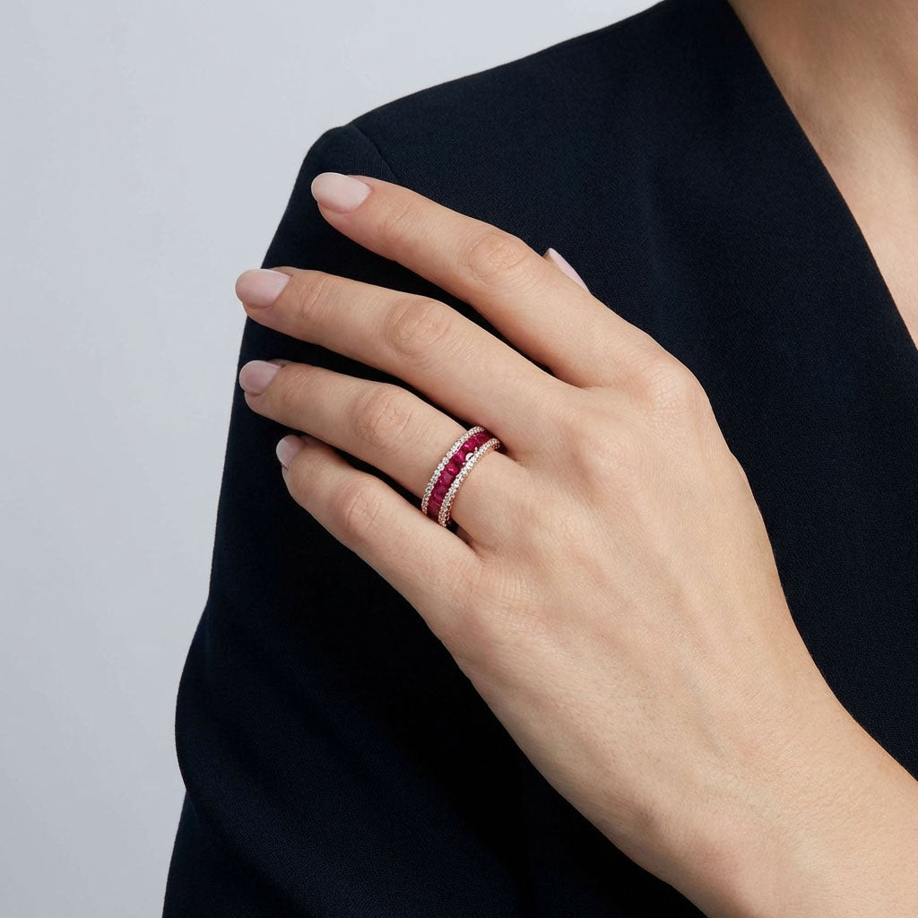 Woman in a black blazer wearing a ring with bright pink stones