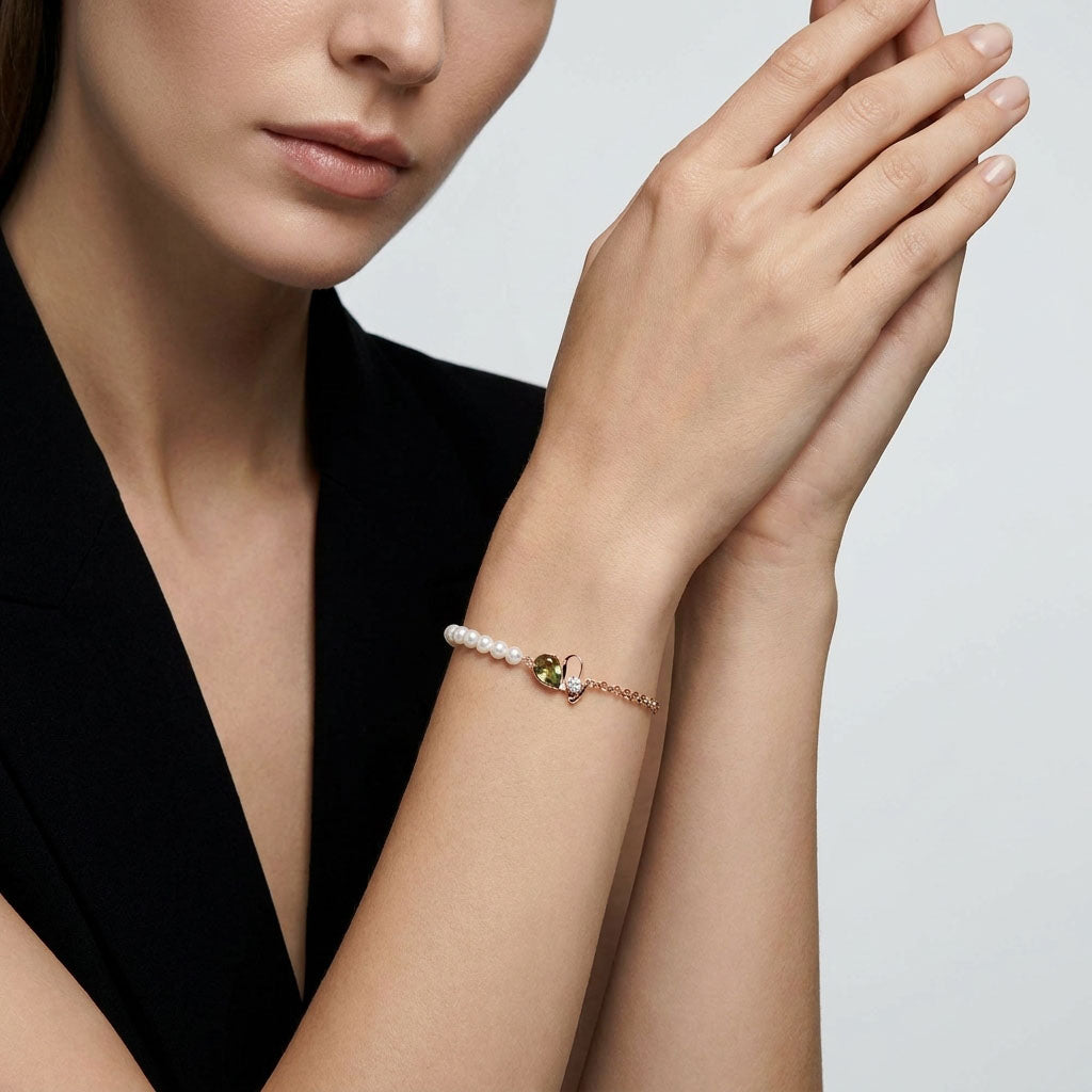 Model wearing a pearl bracelet with a heart against a black jacket