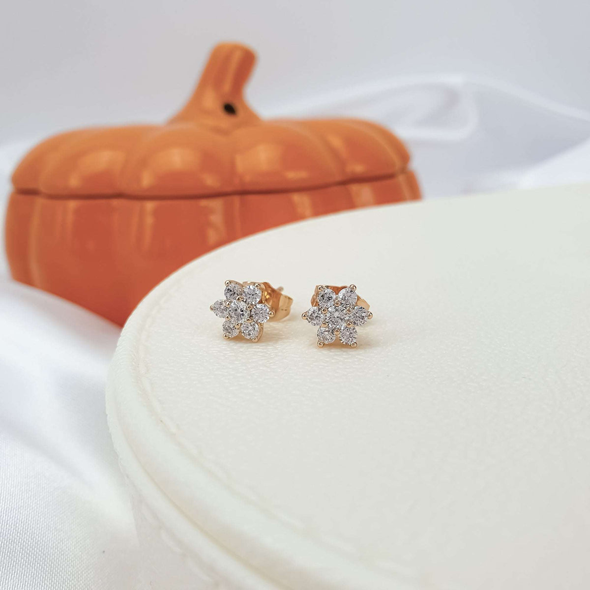 Pair of 9 mm gold-plated studs with seven white cubic zirconia in a flower