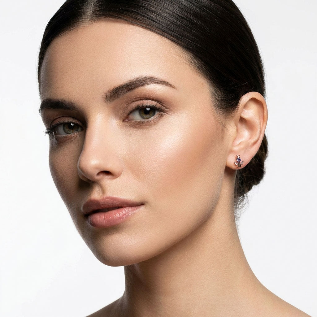 Close-up portrait of a model wearing an angel stud with violet cubic zirconia