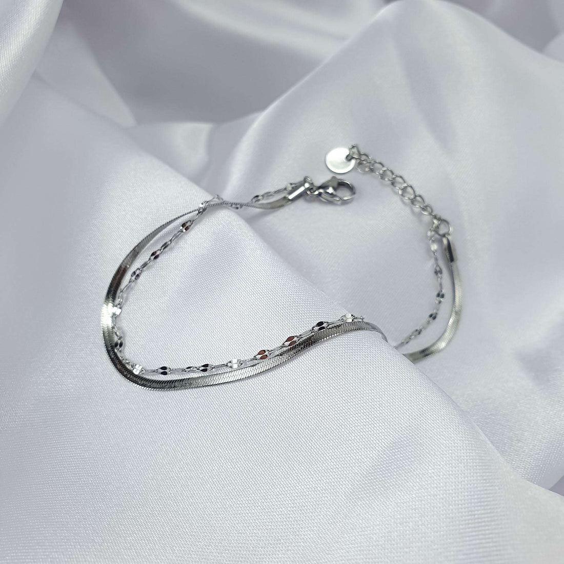 Platinum-plated bracelet with two chain weaves and an adjustable clasp on silk