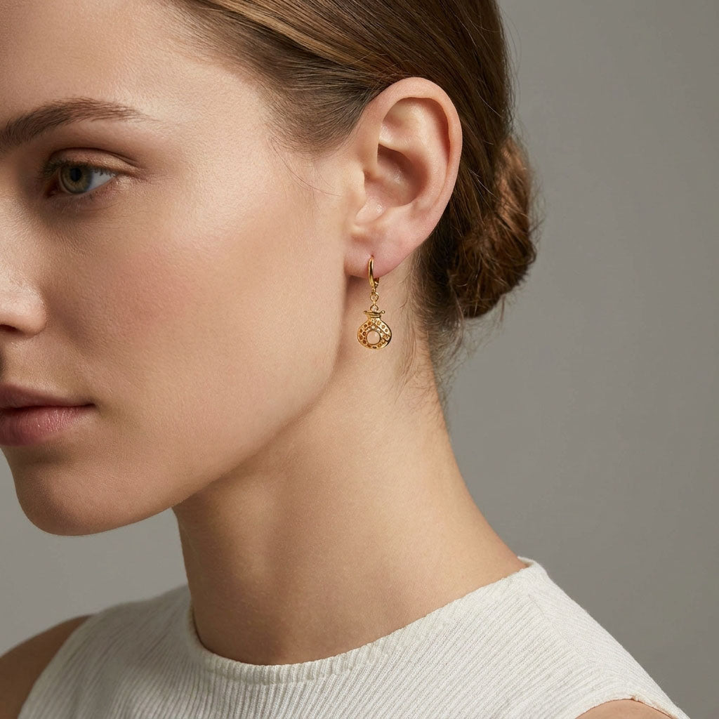Gold-tone pineapple earring with a pale faux pearl, worn by a model