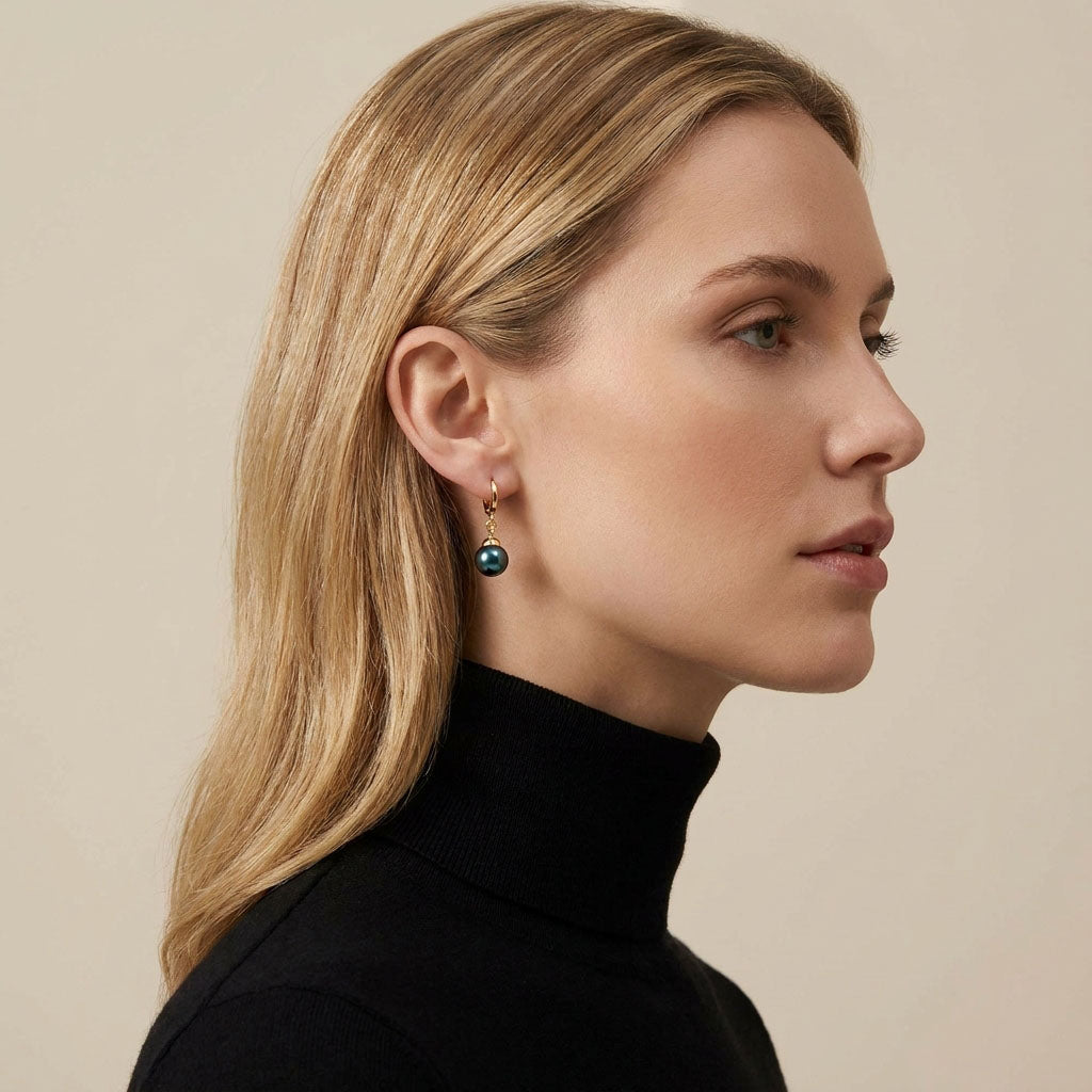Blonde model in a black jumper wearing a dark faux pearl earring