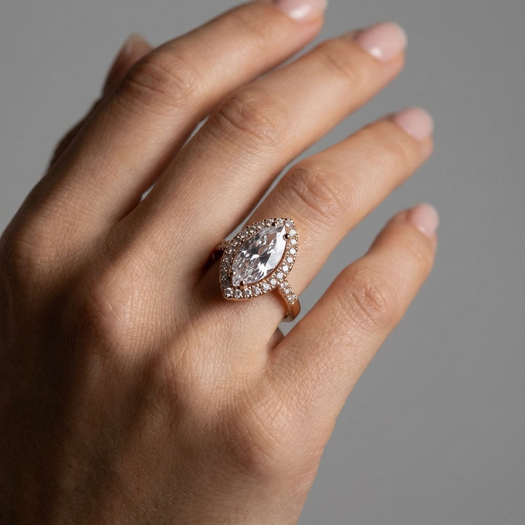 Woman's hand wearing a gold-plated ring with a large marquise zirconia halo