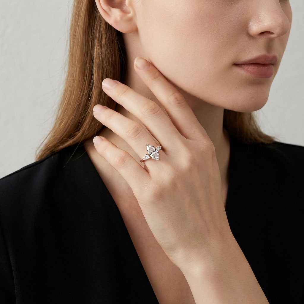 Model wearing the gold-plated three-stone ring, her hand at her neck