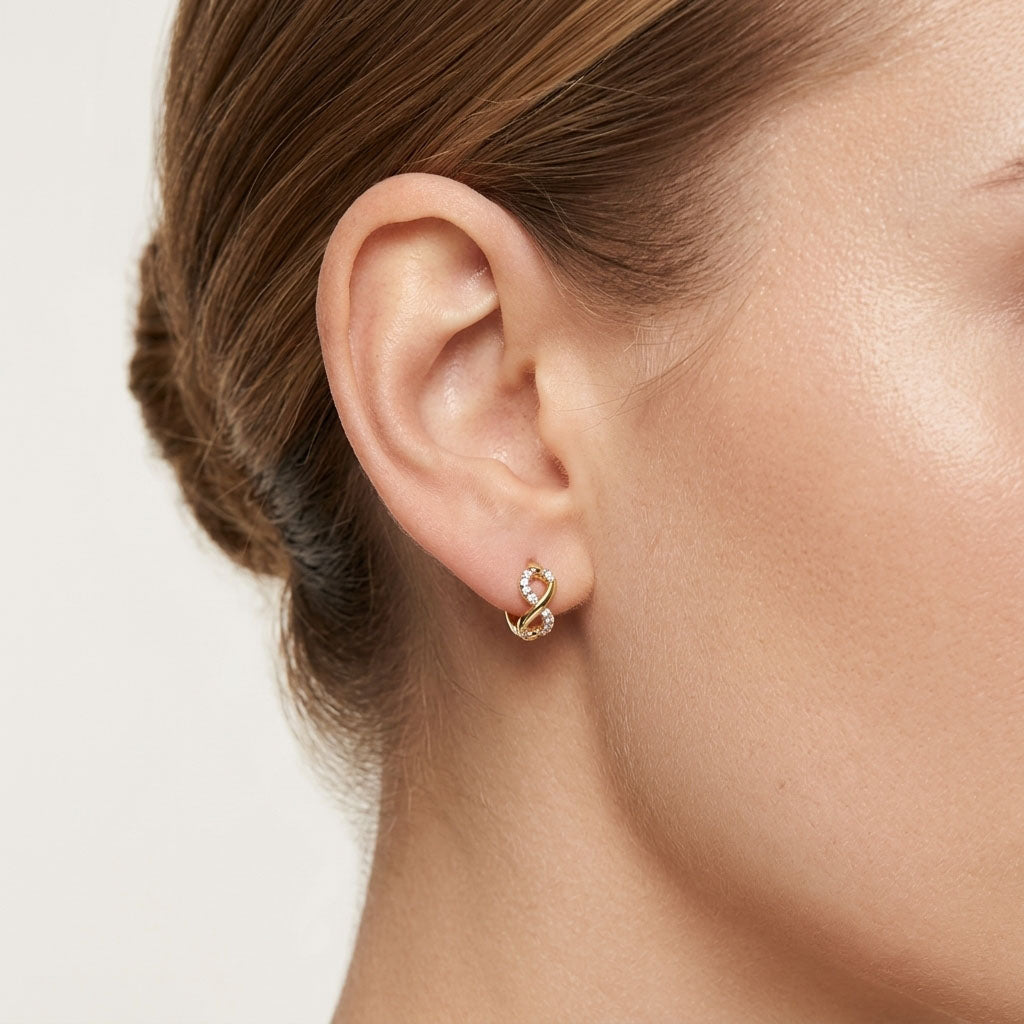 Small infinity earring with cubic zirconia worn in a model's ear
