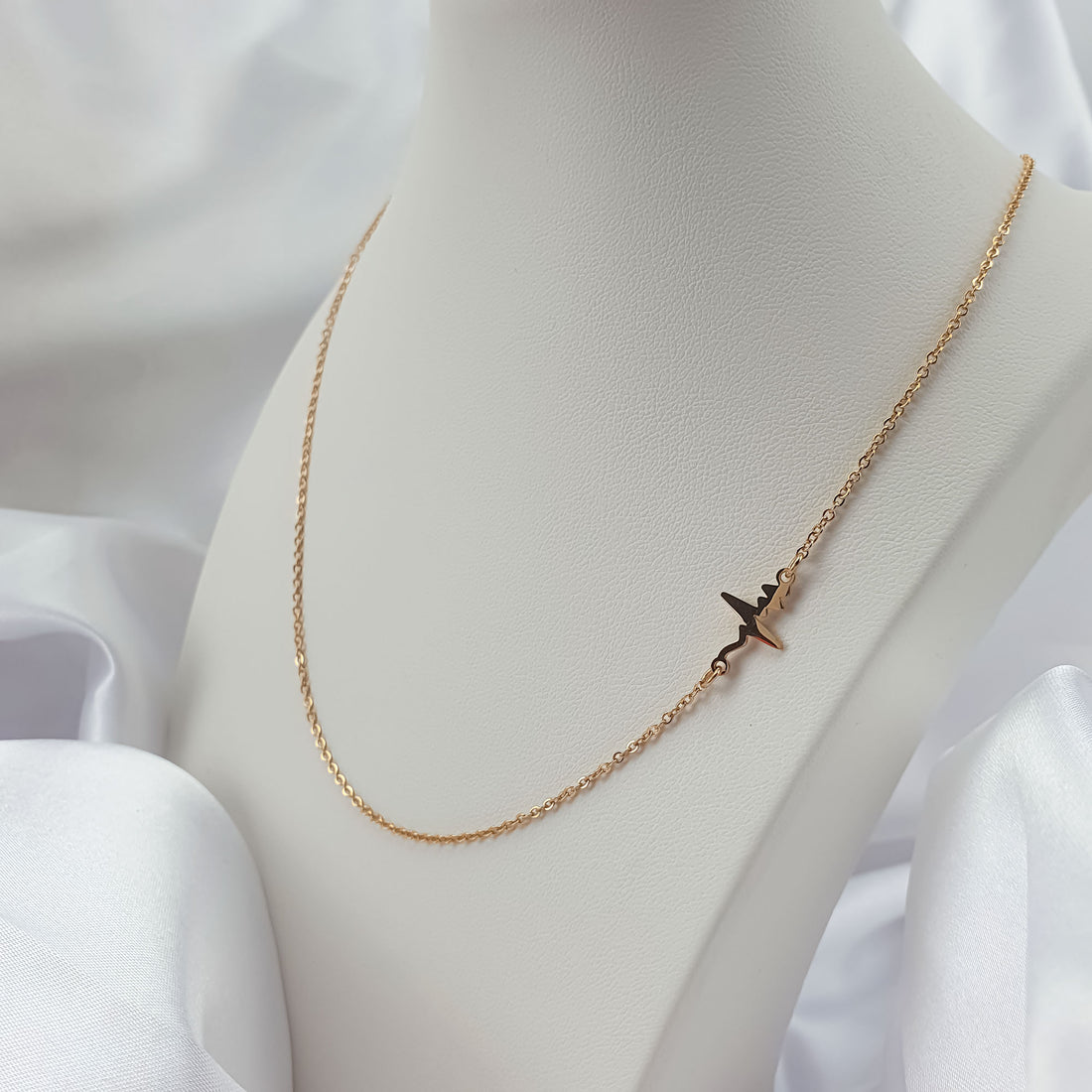 Heartbeat necklace on a white bust, fine gold-plated chain