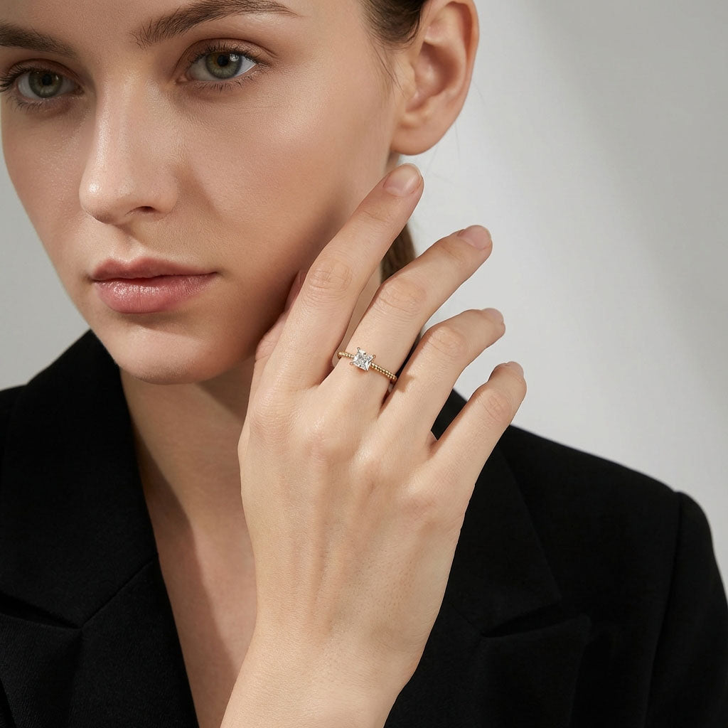 Model in a black blazer showing the slim ring with a square stone
