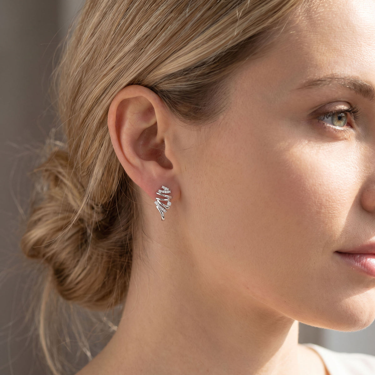 Silver | Silver-tone spiral earring with cubic zirconia worn on the ear