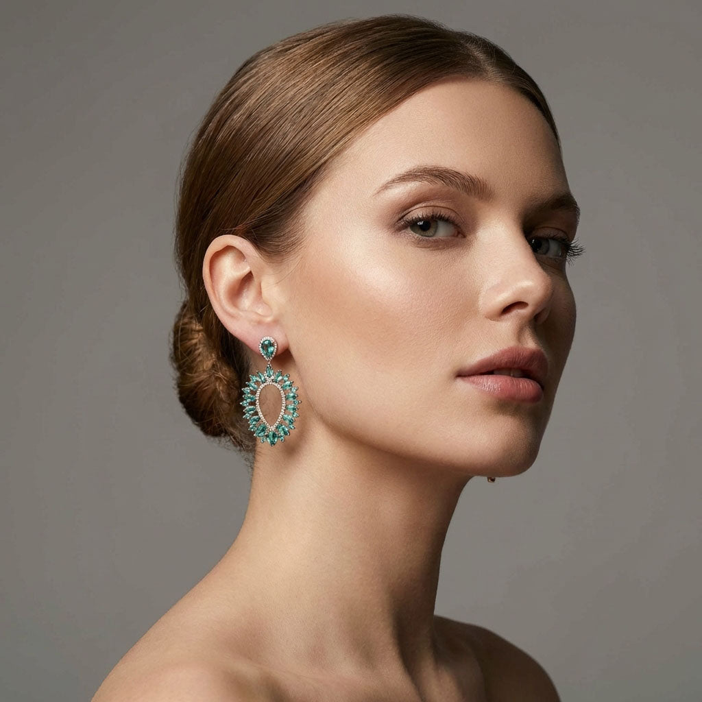 Model in profile wearing drop earrings with light green stones and white zirconia