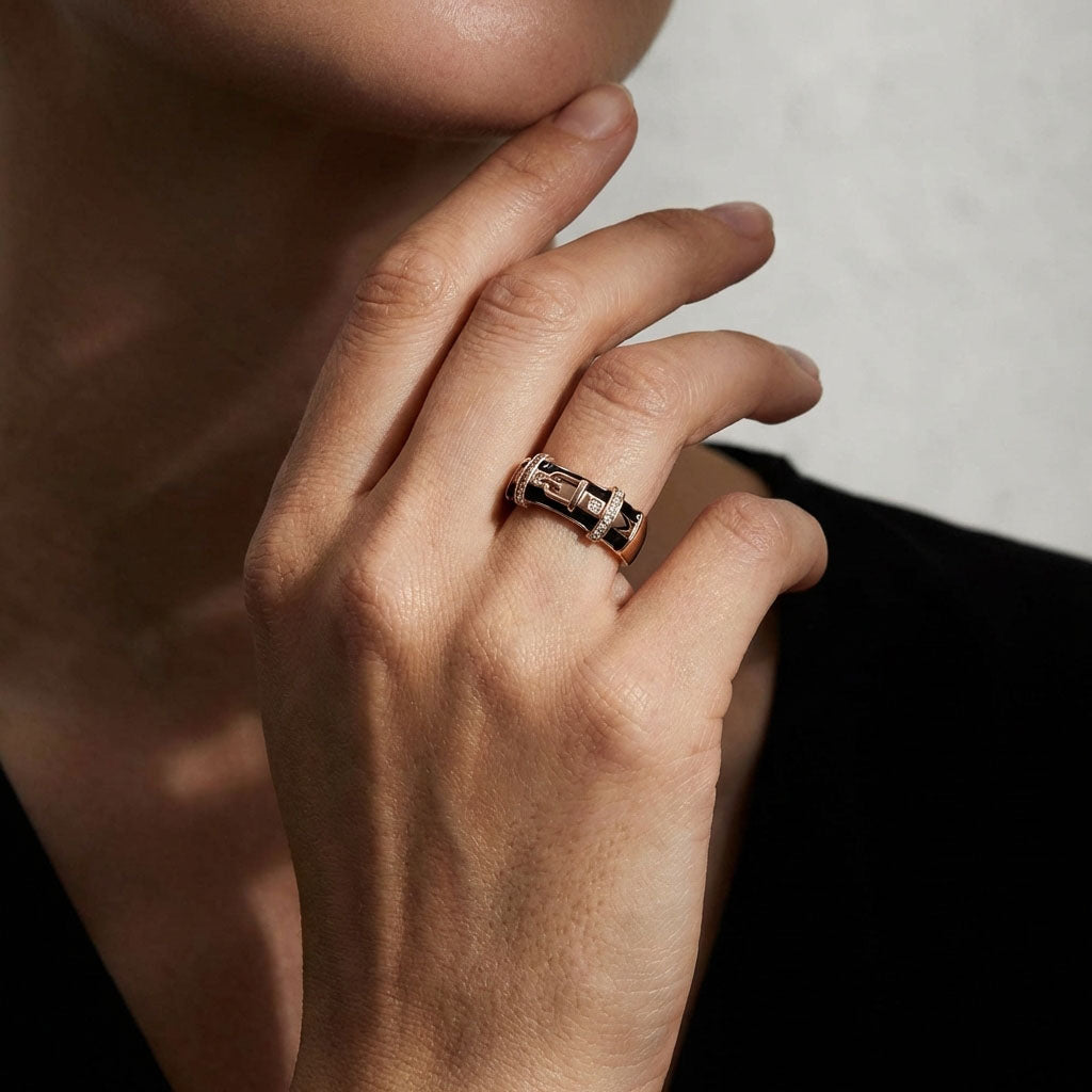 Black enamel belt ring on a model's finger, showing its width and buckle