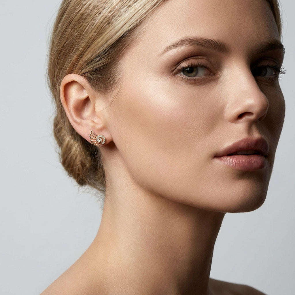Model wearing small wing-shaped studs with a spiral of stones