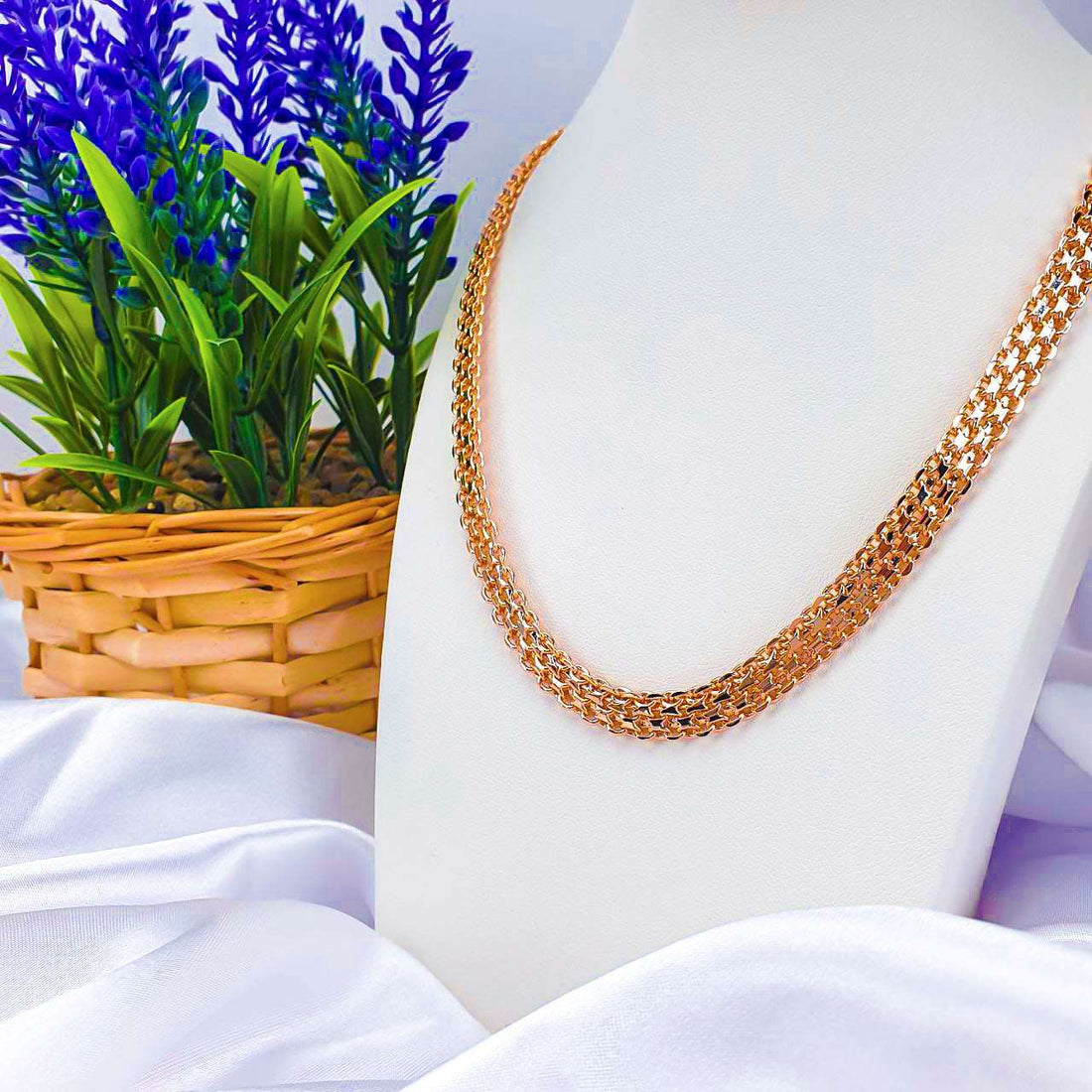 Gold-plated Bismarck chain on a white display bust beside a lavender basket