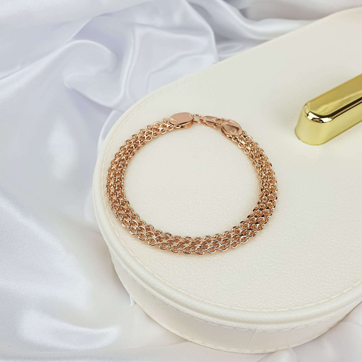 Gold-plated Bismarck bracelet on a white jewellery box with satin behind