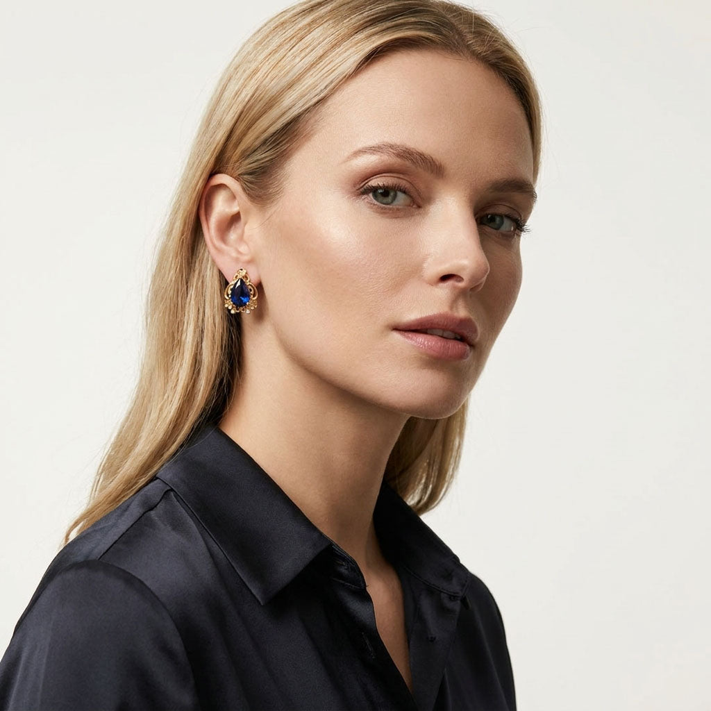 Blue teardrop clip-on earring on a blonde model in a black silk shirt