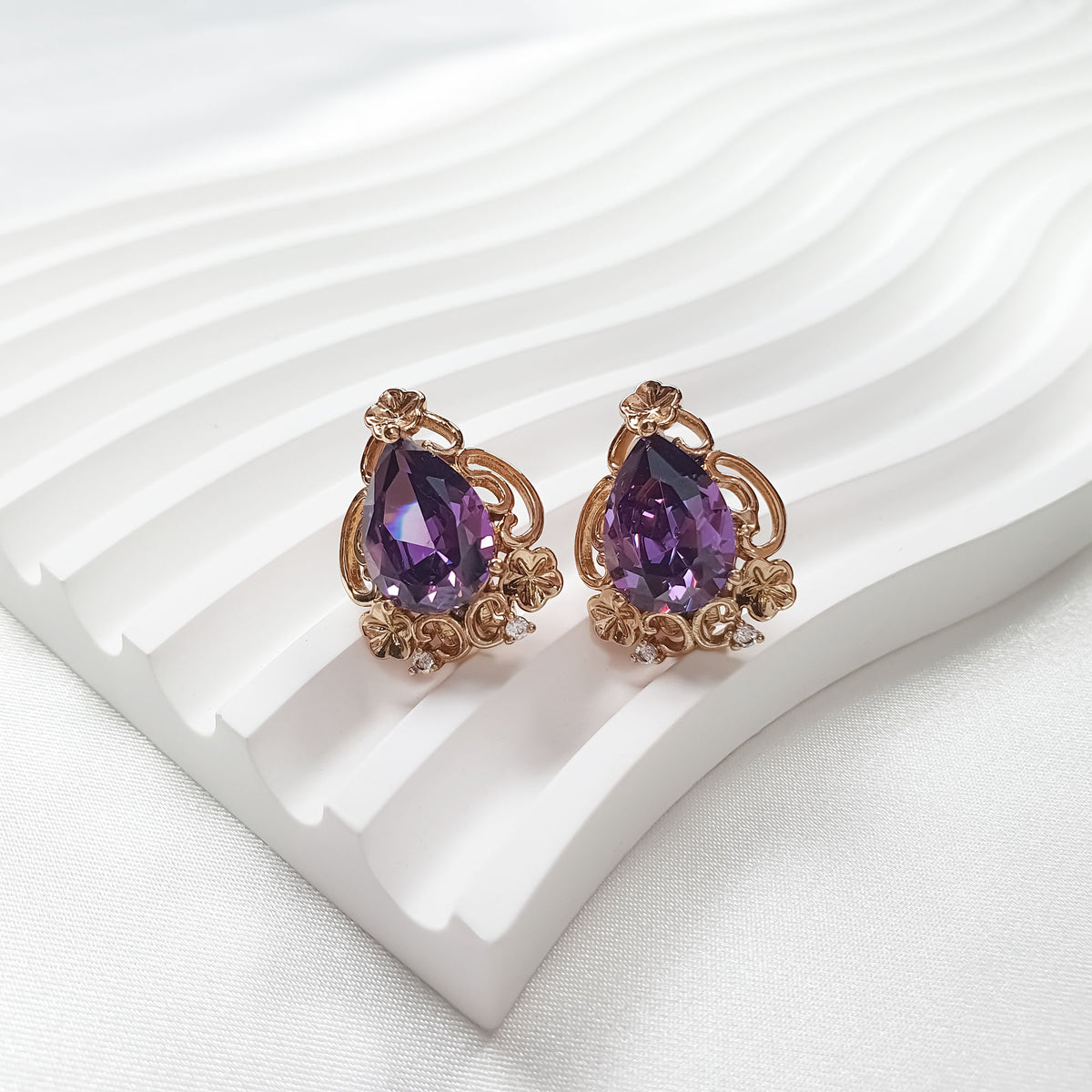 Pair of gold-plated clip-on earrings with violet pear-shaped crystals and tiny cubic zirconia