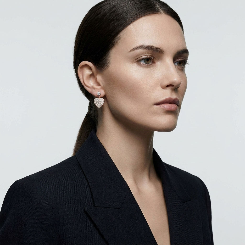 Model in profile wearing gold-plated heart earrings with cubic zirconia