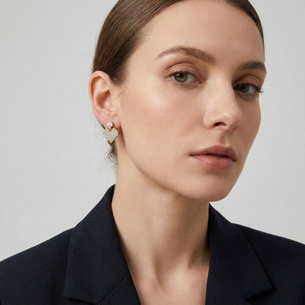Model in a dark blazer wearing mosaic heart earrings with cubic zirconia