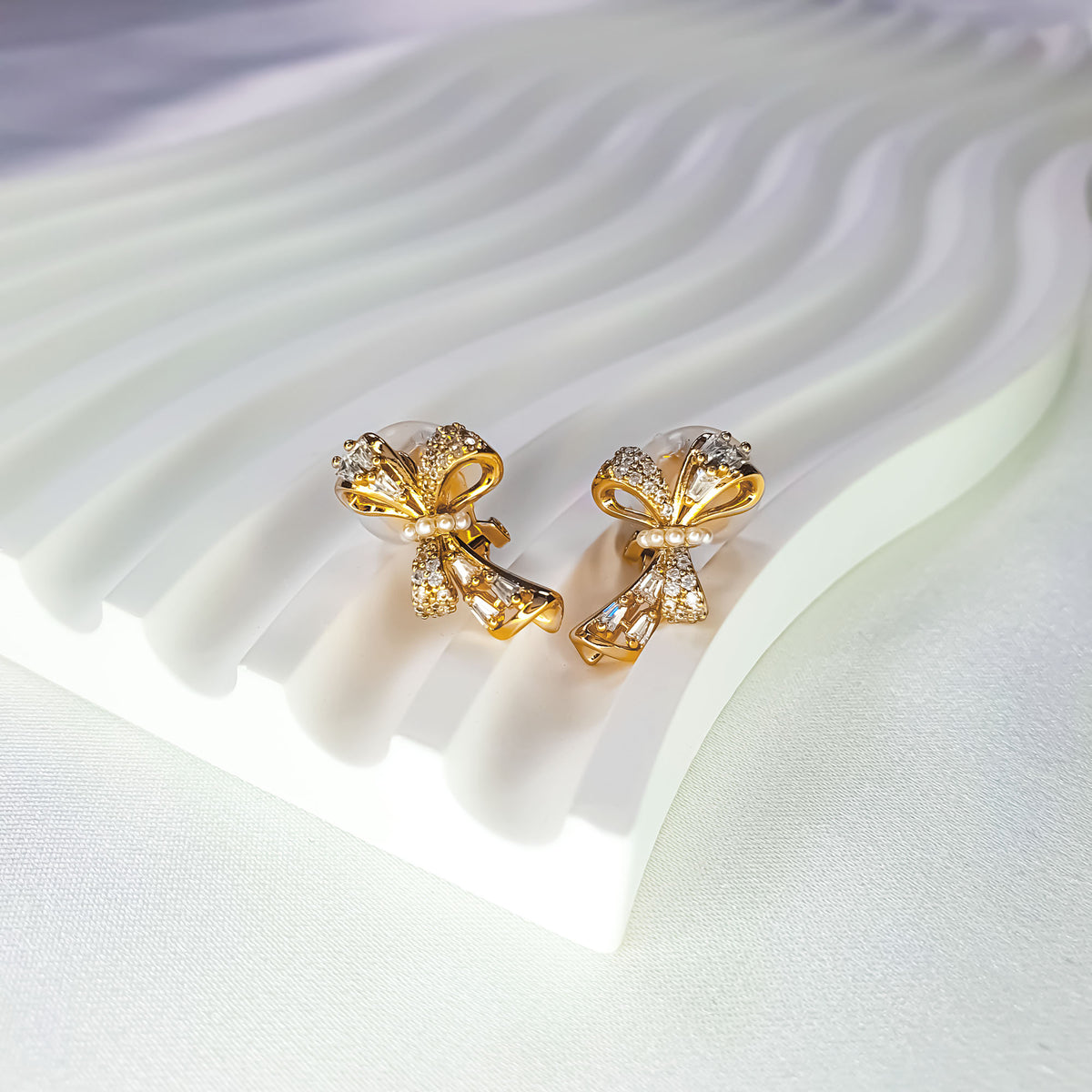 Bow earrings at an angle showing the clip-on fastening and pearls