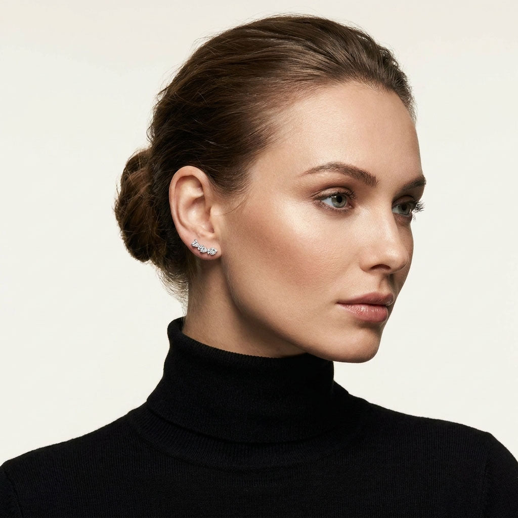 Heart cubic zirconia stud on a model's ear against a black roll-neck