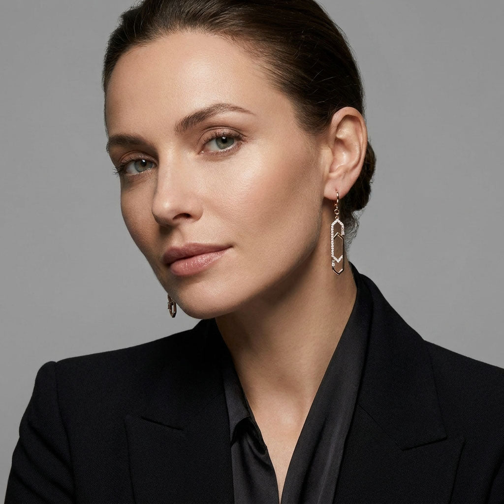 Model in a black blazer wearing long gold-plated earrings with cubic zirconia