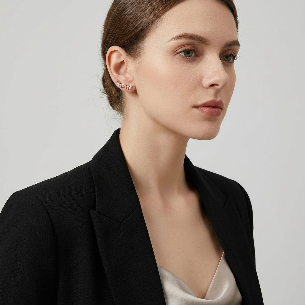 Model in a black jacket wearing flower ear climbers curving along the ear